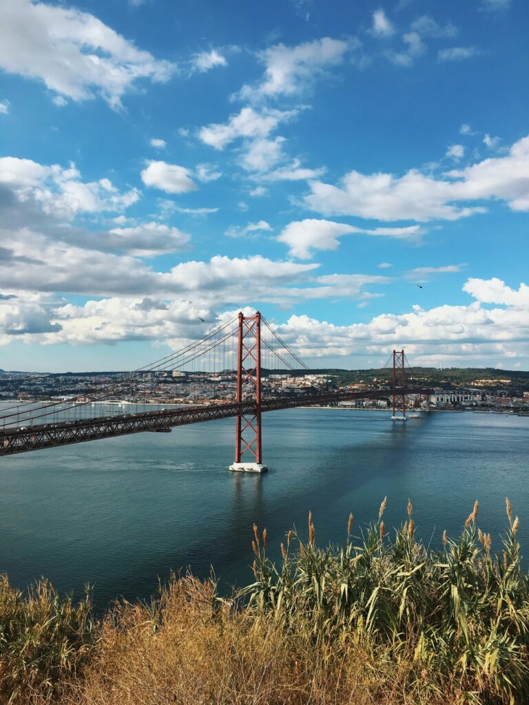 Stunning view of Ponte 25 de Abril bridge over the Tagus River in Lisbon on a bright summer day.
