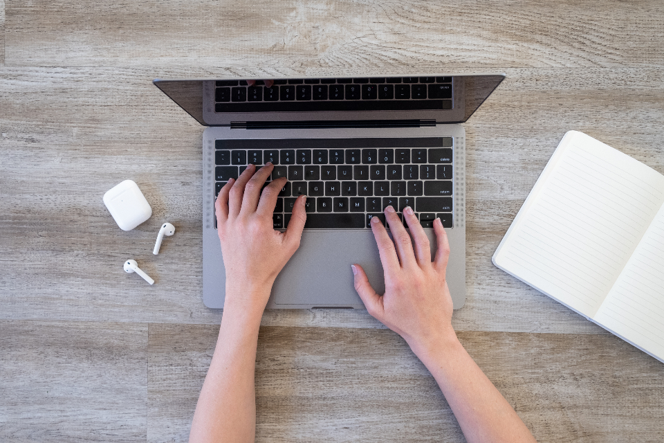 Maos a digitar num teclado de computador portatil
