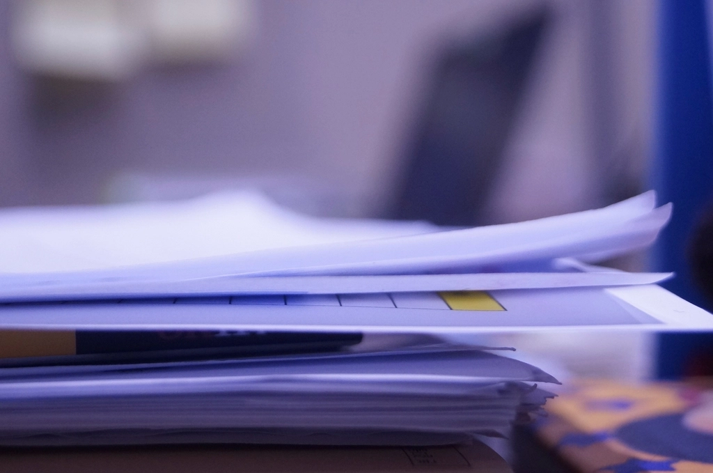 Pessoa a organizar documentos num balcao de atendimento