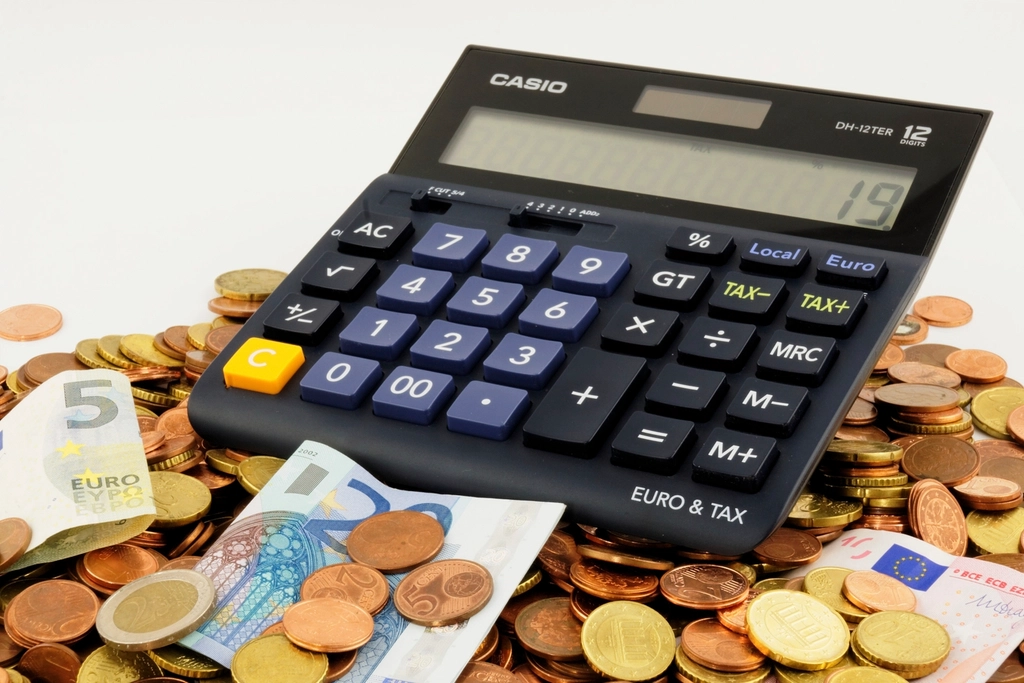 Calculadora e moedas de euro sobre a mesa