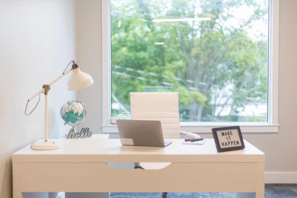 Computador portatil junto a uma janela em ambiente de trabalho remoto
