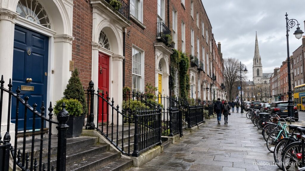 Rua de casas georgianas de tijolo em Dublin com portas coloridas, gradeamento preto e bicicletas encostadas ao passeio