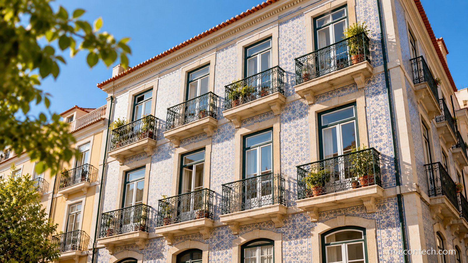 Fachada de um prédio de habitação português com azulejo claro e varandas de ferro forjado